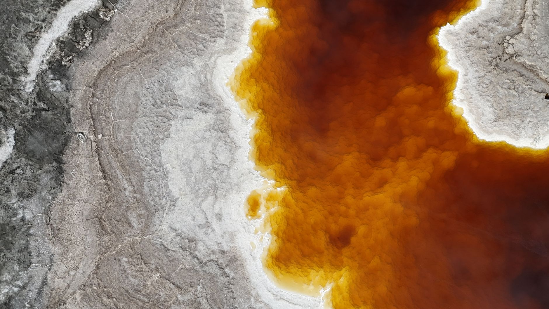 On Titan, rivers carve valleys, rain fills lakes, and a full weather cycle runs exactly as it does on Earth — the only difference is that the rain is liquid methane and the bedrock those rivers cut through is water ice frozen harder than granite